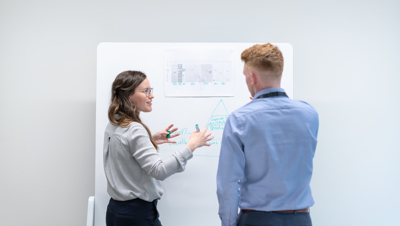 Colleagues working through ideas together at a whiteboard